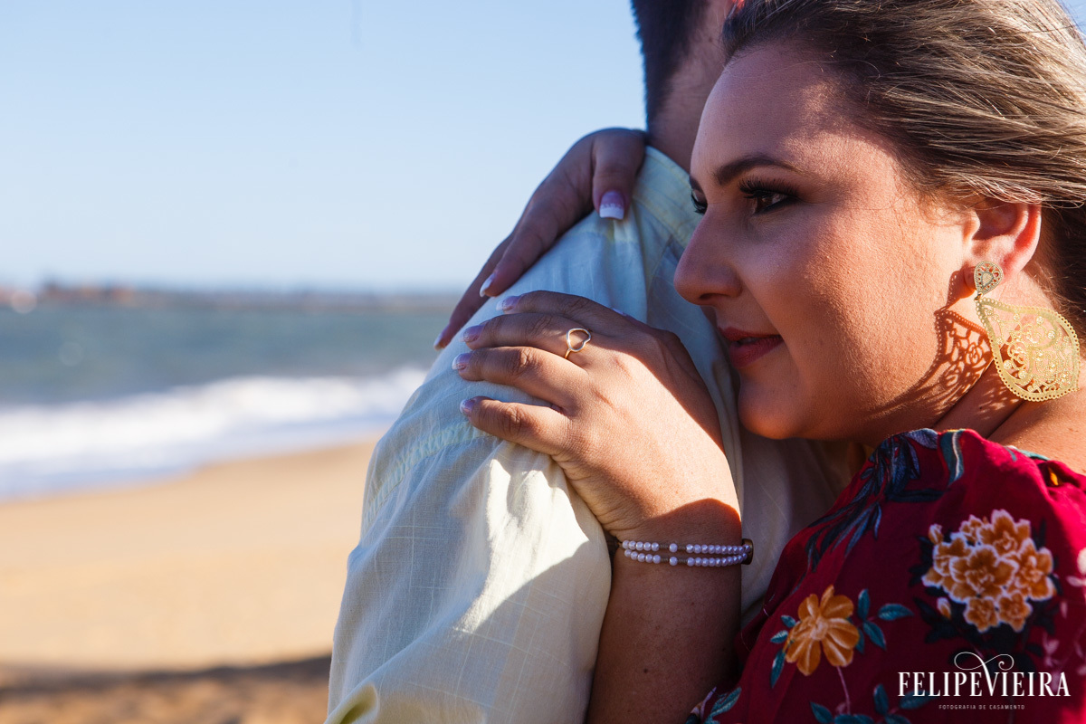 ensaio pré casamento na praia em Guarapari Espírito Santo com a noiva aproveitando o abraço do noivo com a praia ao fundo foto de Felipe Vieira Fotografo de casamento em Guarapari Espírito Santo