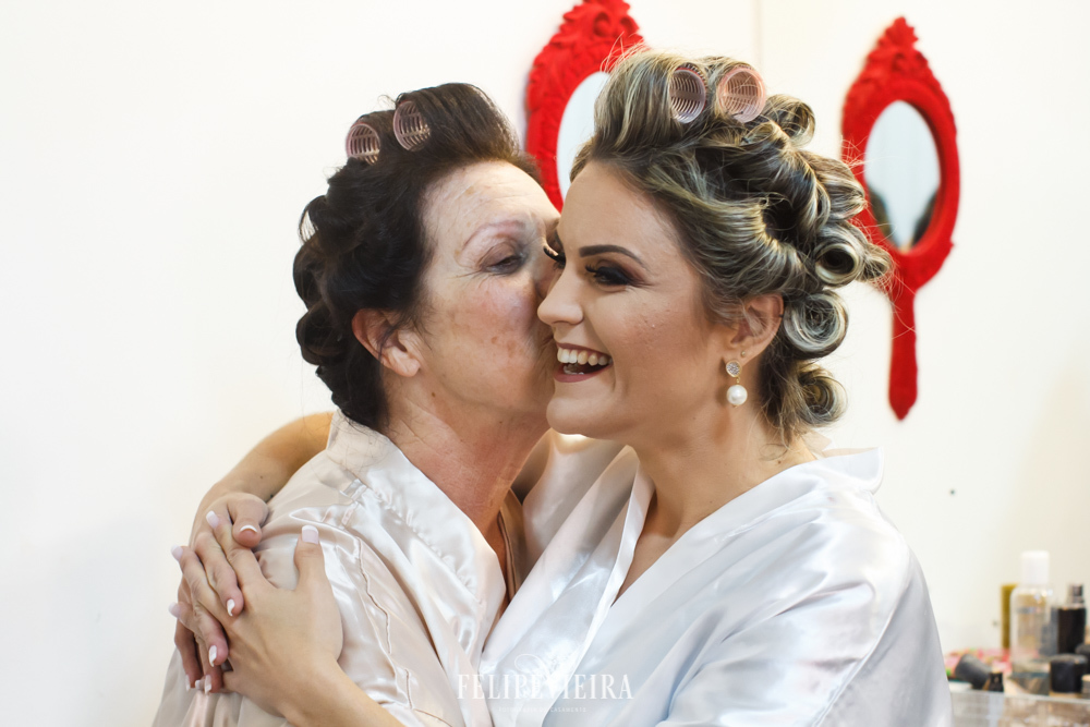 mão beijando a noiva no salão durante making of da noiva em Guarapari no dia do casamento