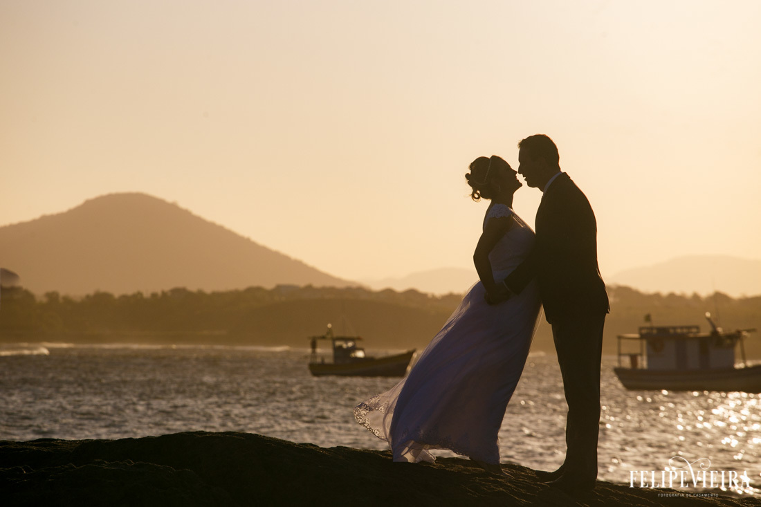 silhueta de noivos em frente ao mar e à barquinhos foto feita por felipe vieira fotografo de casamentos em guarapari