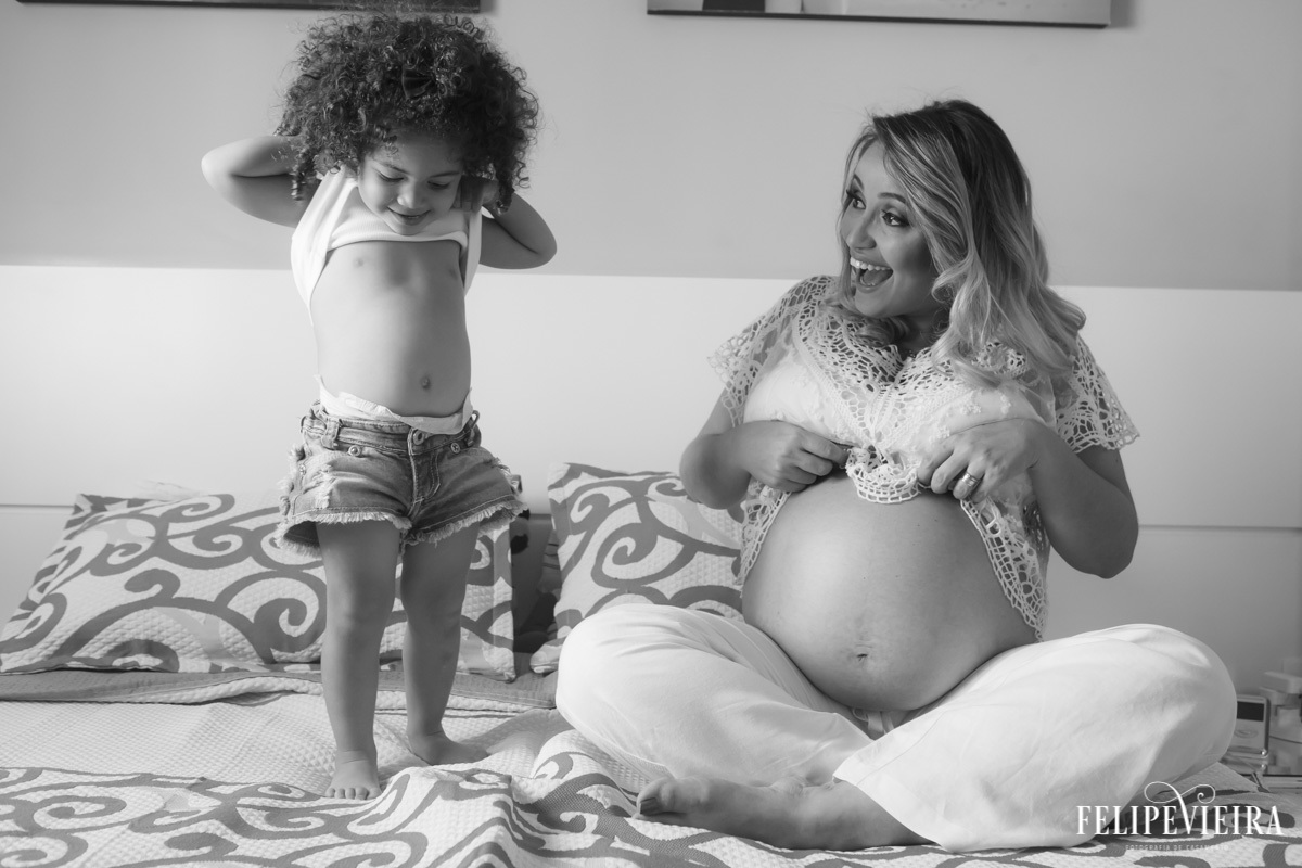Mãe e filha mostrando a barriga de gestante em foto feita por felipe vieira fotógrafo em guarapari espírito santo