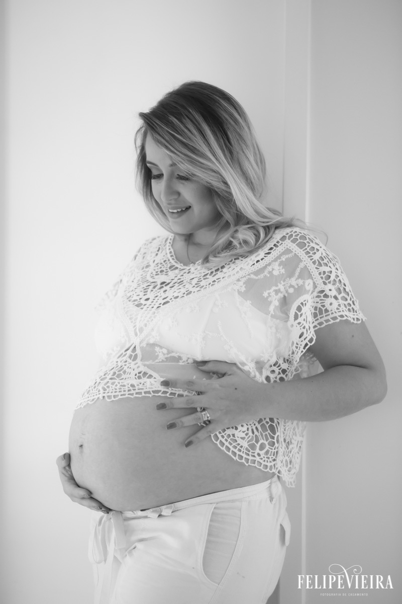 foto de gestante sorrindo com as mãos na barriga em foto feita por felipe vieira fotógrafo em guarapari espírito santo