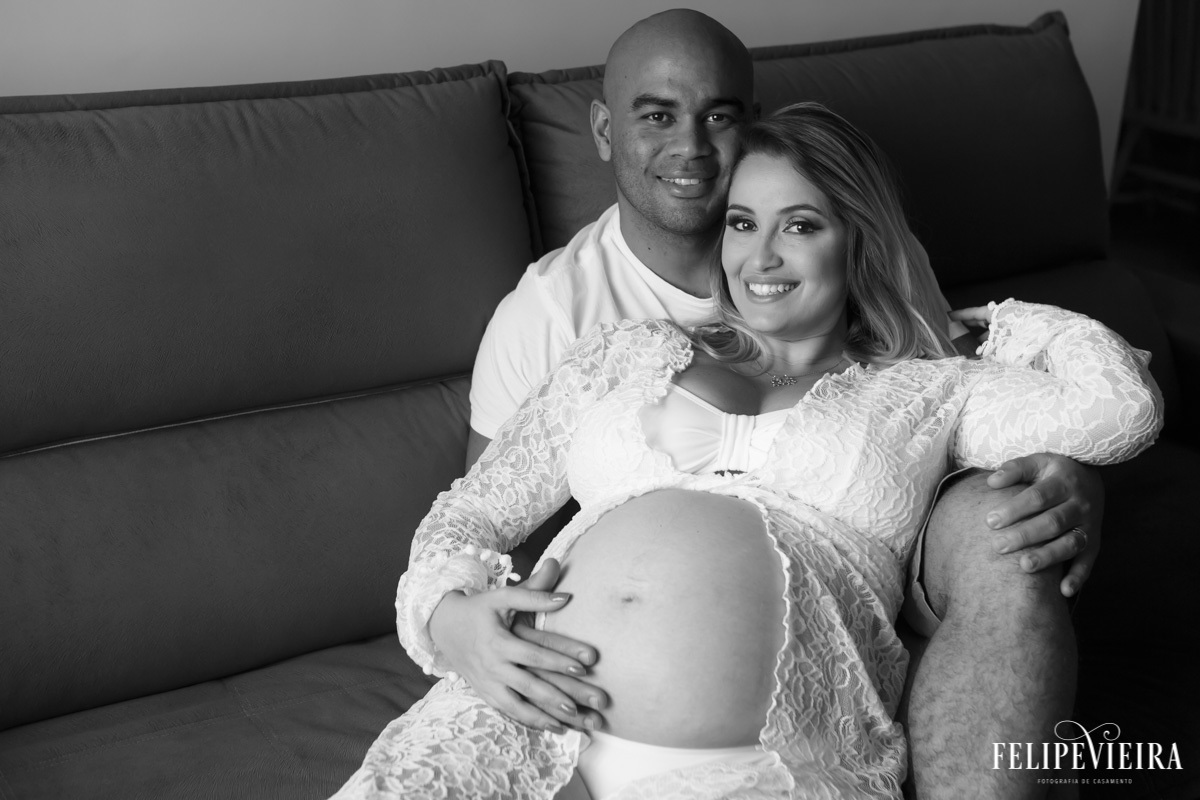 marido e esposa abraçados com a mão em sua barriga em foto feita por felipe vieira fotógrafo em guarapari espírito santo