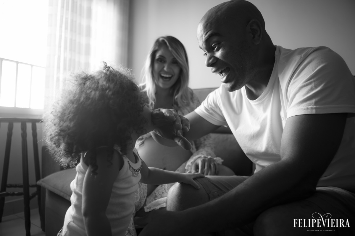 filha mordendo o pai e todos sorrindo em foto em preto e branco em foto feita por felipe vieira fotógrafo em guarapari espírito santo