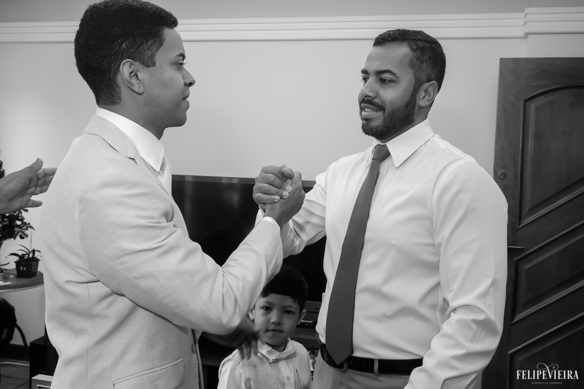 noivo cumprimentando padrinho enquanto se aprontam para o casamento em feita por Felipe Vieira fotografo de casamentos em guarapari e grande vitória