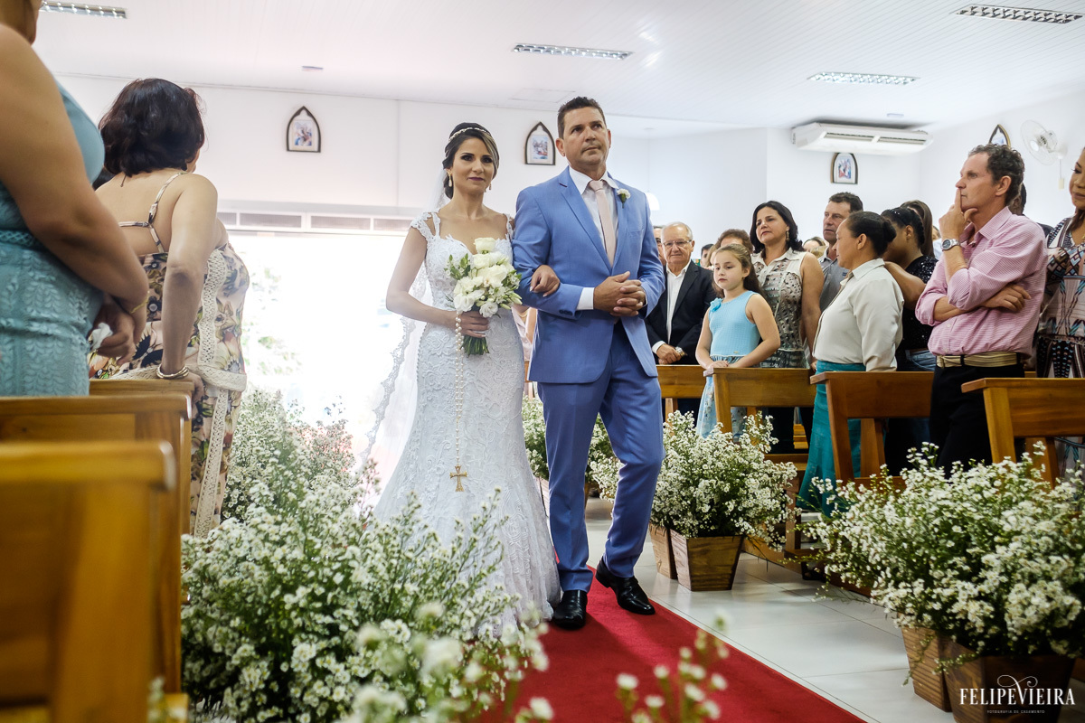noiva entrando na igreja com seu pai e sorrindo em feita por Felipe Vieira fotografo de casamentos em guarapari e grande vitória