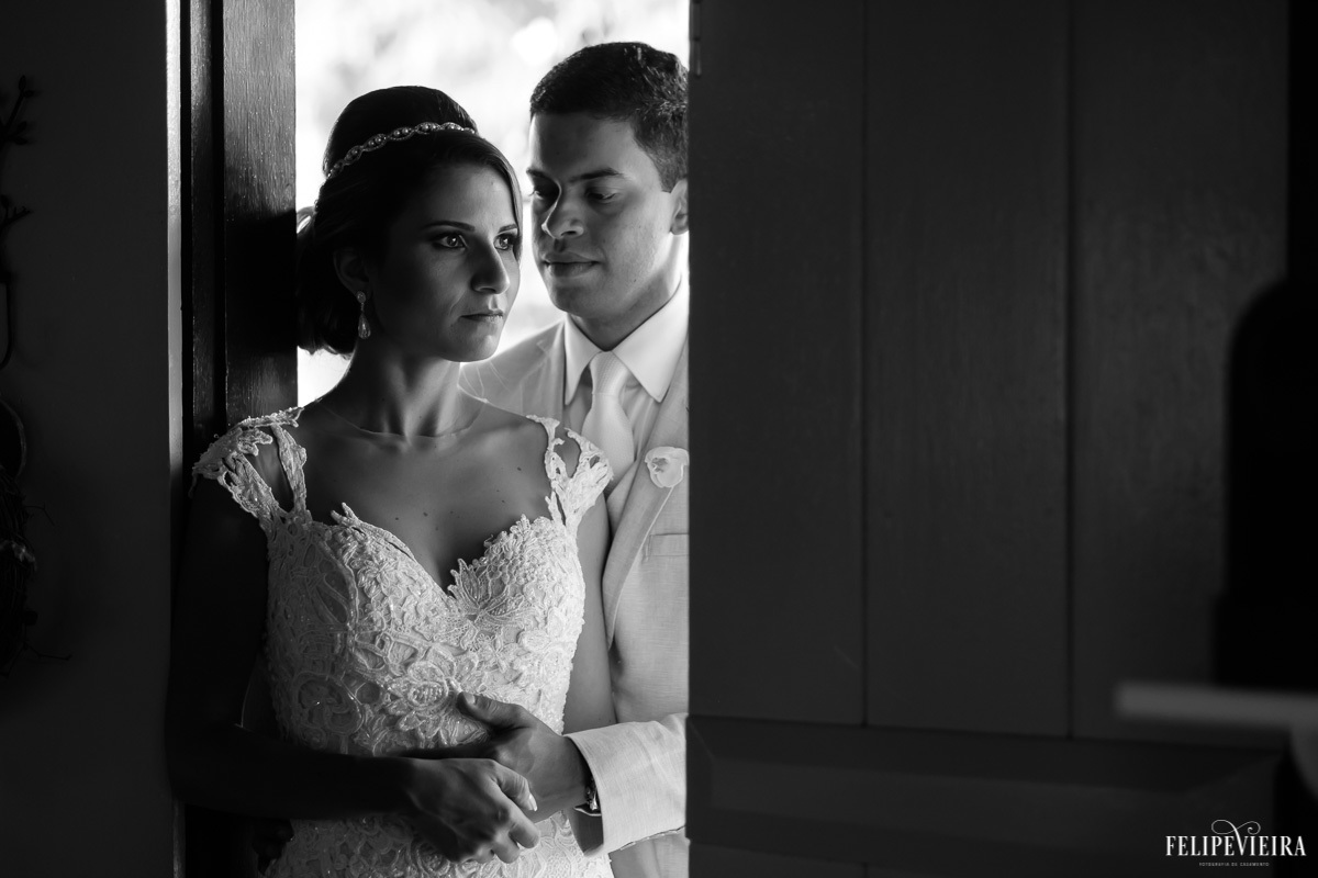 noivos em frente a uma porta, abraçados em foto em preto e branco em ensaio externo em feita por Felipe Vieira fotografo de casamentos em guarapari e grande vitória