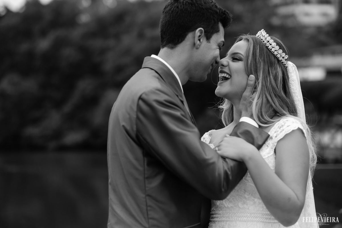 noivos felizes e sorrindo um para o outro e noivo com a mão no rosto da noiva em foto em preto e branco feita por Felipe Vieira fotografo de casamentos em guarapari e grande vitória