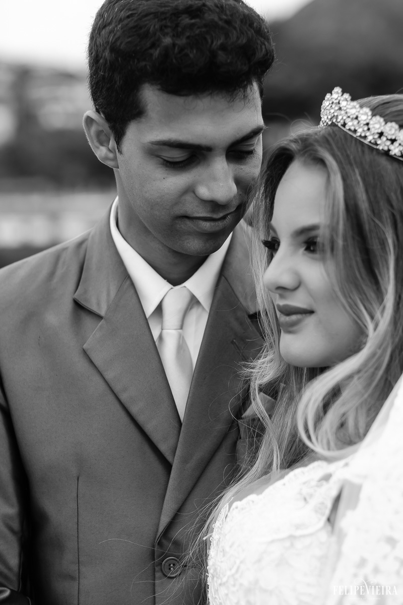 Foto com rosto da noiva e sorriso com detalhes do paletó do noivo em foto em preto e branco feita por Felipe Vieira fotografo de casamentos em guarapari e grande vitória