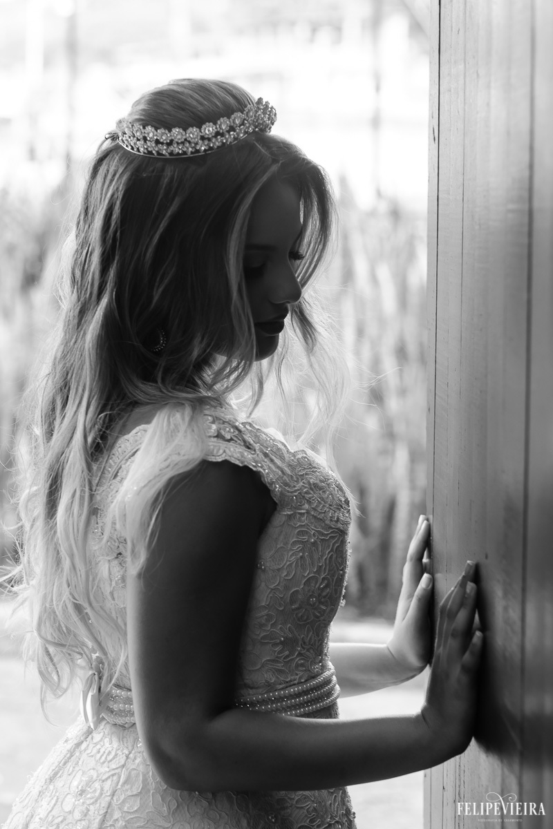noiva olhando para baixo com detalhes do vestido de noiva em foto em preto e branco feita por Felipe Vieira fotografo de casamentos em guarapari e grande vitória