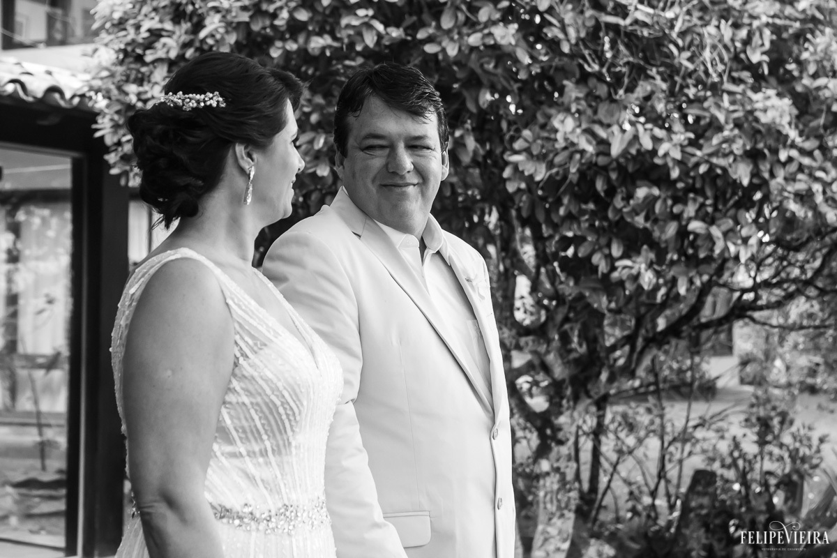 noivos se olhando e sorrindo em foto em preto branco em feita por Felipe Vieira fotografo de casamentos em guarapari e grande vitória
