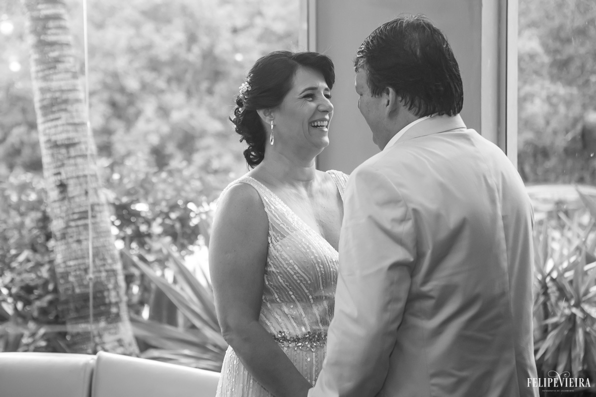 noivos de frente um para o outro e sorrindo em foto em preto e branco em feita por Felipe Vieira fotografo de casamentos em guarapari e grande vitória