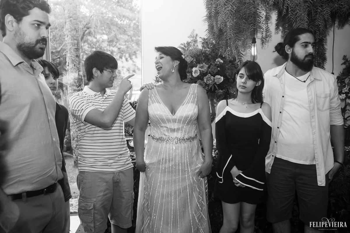noiva de mãos dadas com sua família em foto em preto e branco em feita por Felipe Vieira fotografo de casamentos em guarapari e grande vitória
