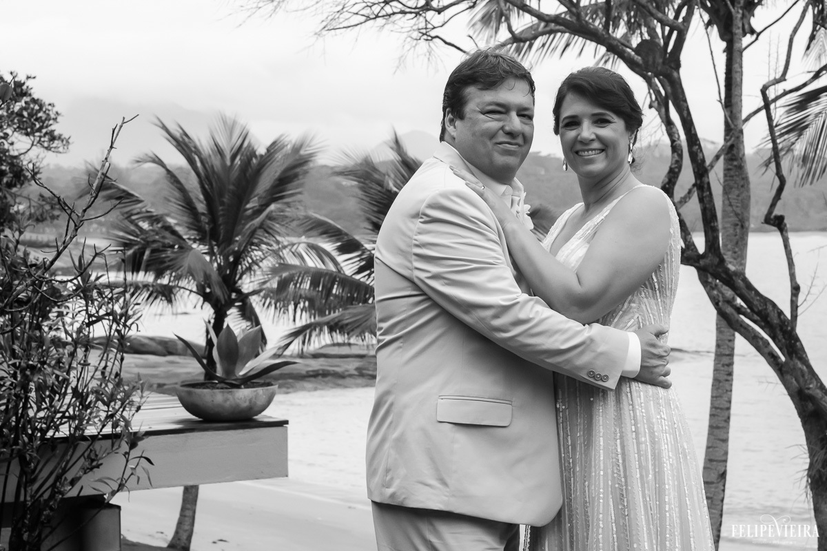 noivos abraçados e sorrindo em foto em preto e branco em feita por Felipe Vieira fotografo de casamentos em guarapari e grande vitória