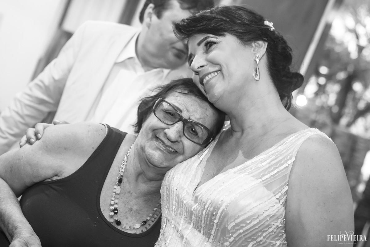 noiva abraçada com a familia e sorrindo em foto em preto e branco em feita por Felipe Vieira fotografo de casamentos em guarapari e grande vitória