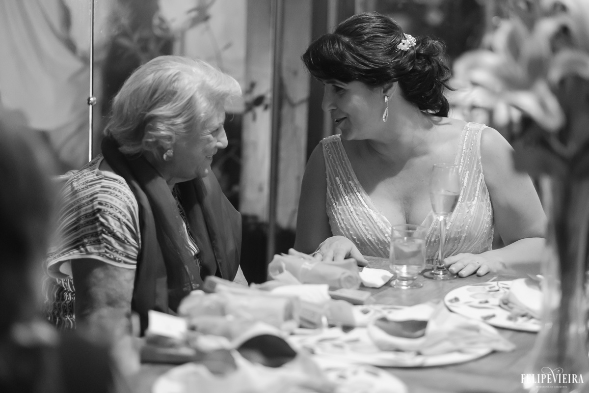 noiva a mesa com convidados conversando e sorrindo em feita por Felipe Vieira fotografo de casamentos em guarapari e grande vitória