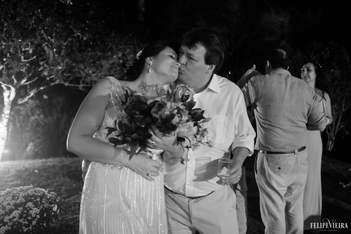 noivos abraçados e se beijando na festa em foto em pretoe branco em feita por Felipe Vieira fotografo de casamentos em guarapari e grande vitória