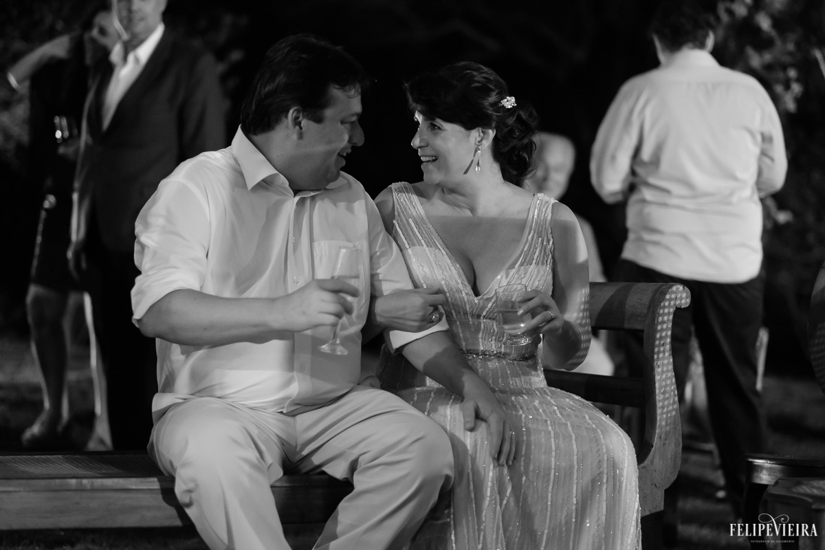 noivos sentados e conversando na festa em feita por Felipe Vieira fotografo de casamentos em guarapari e grande vitória