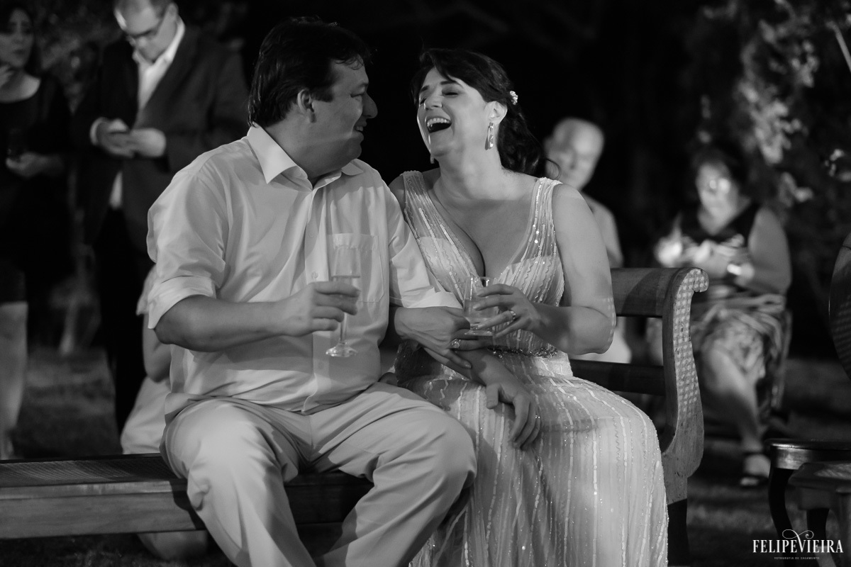 noivos sentados e sorrindo enquanto conversam em feita por Felipe Vieira fotografo de casamentos em guarapari e grande vitória