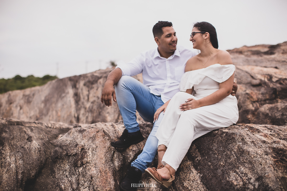 noivos sentados na pedra ensaio pré casamento em Meaípe em Guarapari-ES