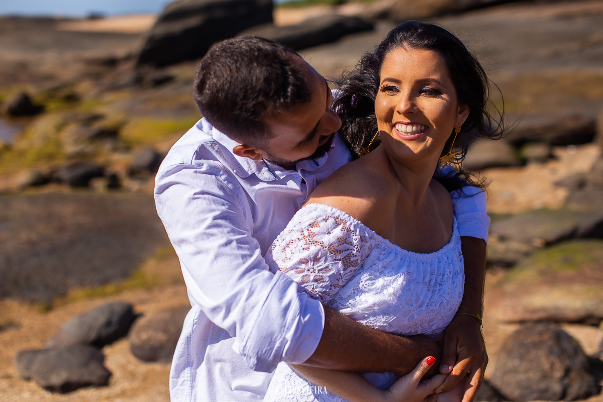 ensaio pré wedding casal na praia em Guarapari noivo abraçando a noiva