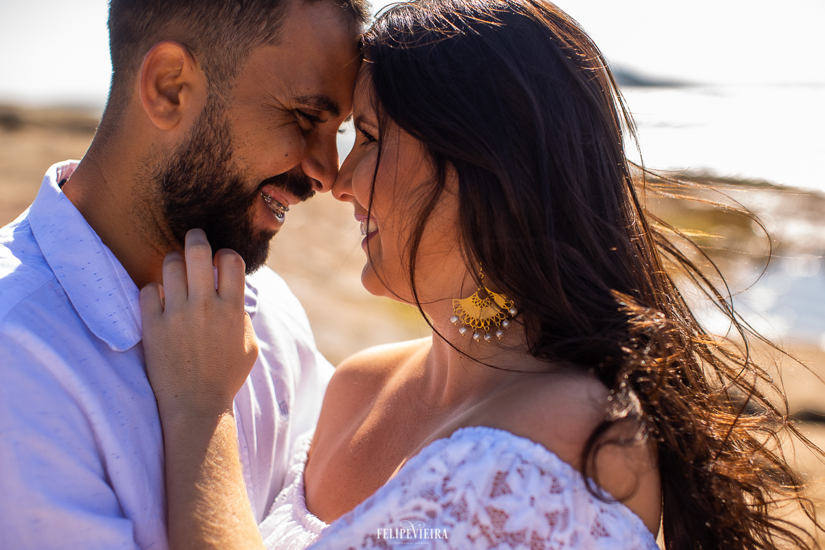 noivo abraçando a noiva com roupas brancas