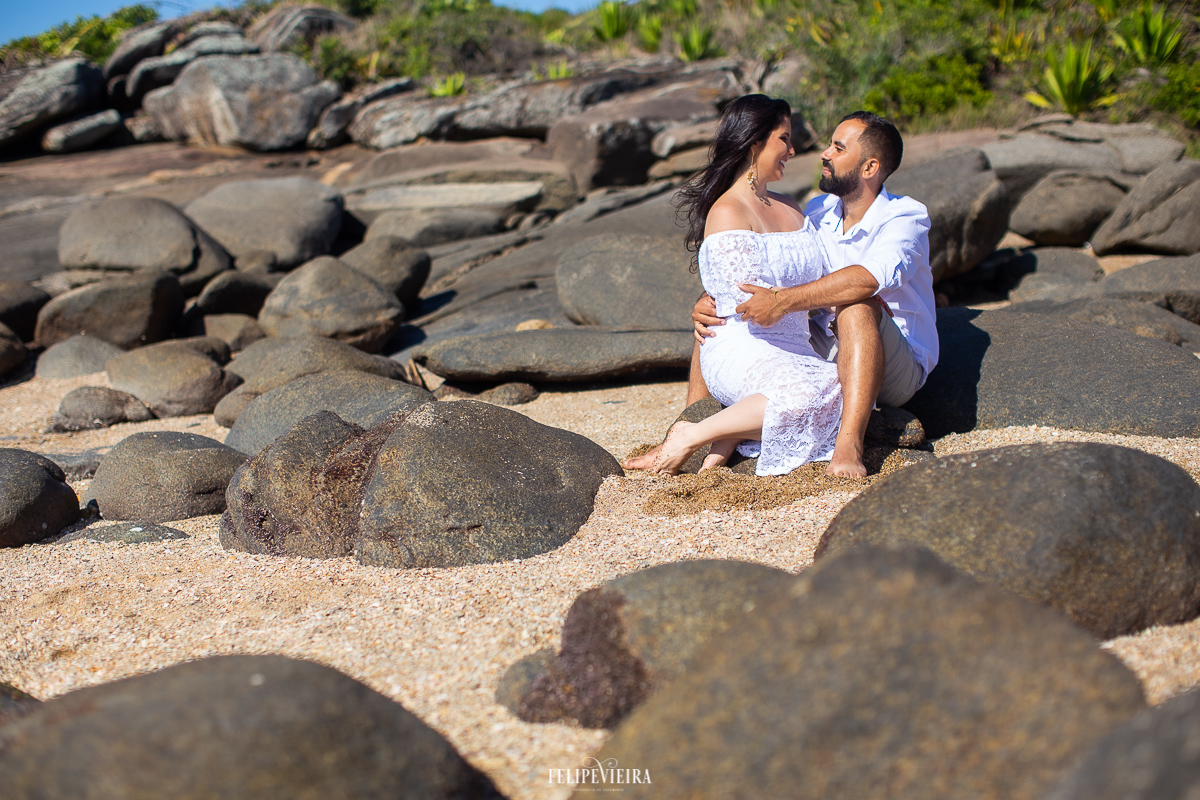casal sentado pedras praia vestido branco ensaio pré wedding