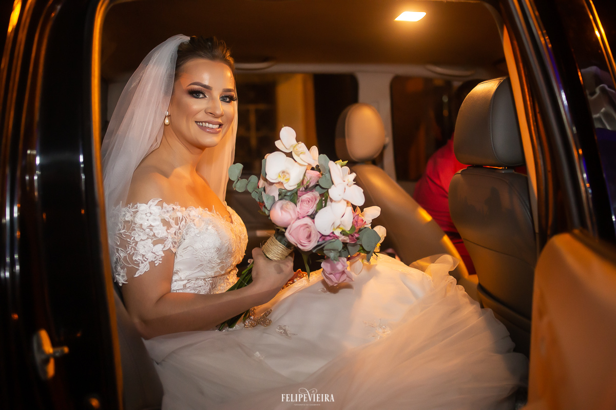 noiva de Alfredo Chaves no carro com buquê de orquídeas na frente a igreja
