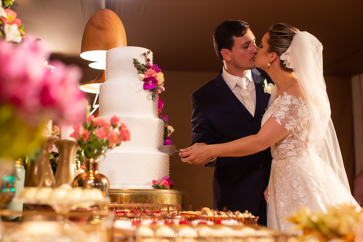 noivos cortando o bolo vestido de noiva em Alfredo Chaves durante festa de casamento