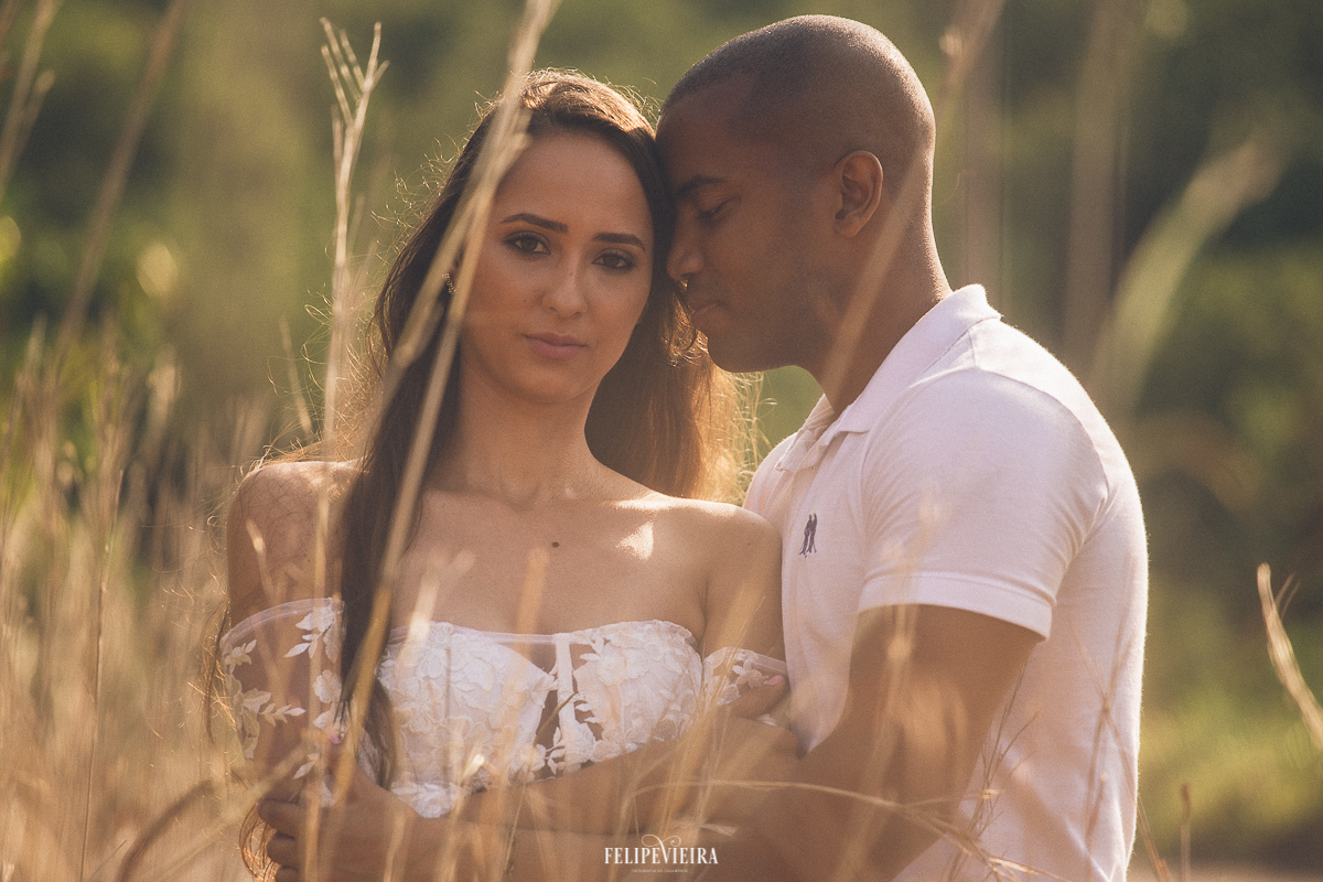 noiva olhando para fotografo de Guarapari em ensaio pré casamento com o noivo encostado nela