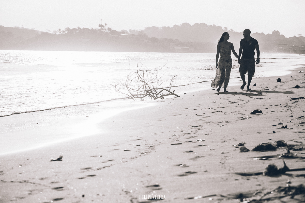 Casal andando na praia de Anchieta durante por do sol 