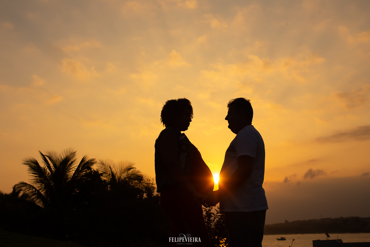 gestante e marido em ensaio fotográfico na luz do por do sol