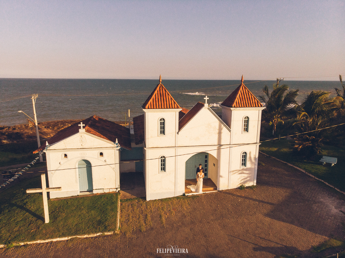 foto aérea da igreja de SantÁna com os noivos na porta da igreja ensaio pós casamento em Guarapari
