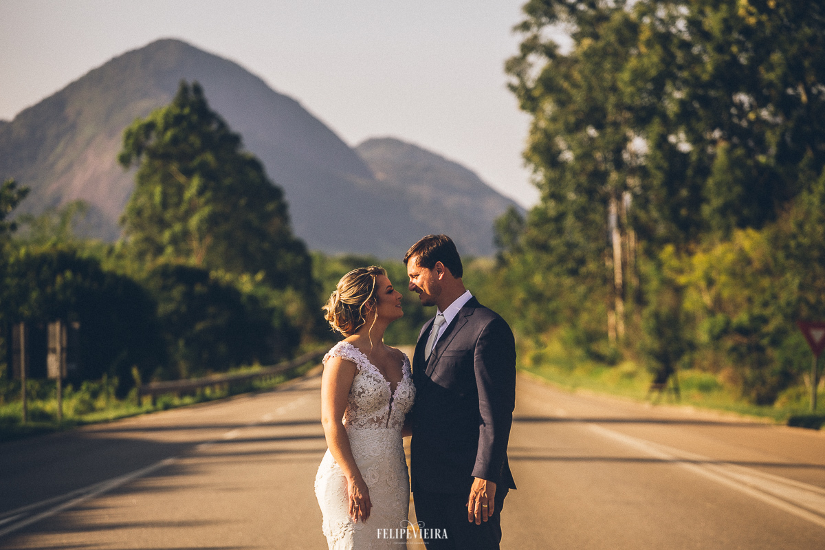 noiva e noivo no meio da estrada em ensaio fotográfico pós casamento