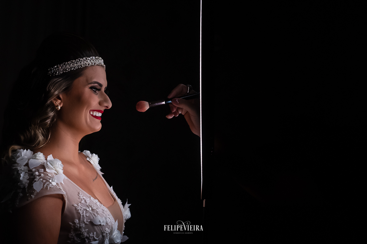 foto da noiva fundo preto e mão da maquiadora da noiva saindo da luz