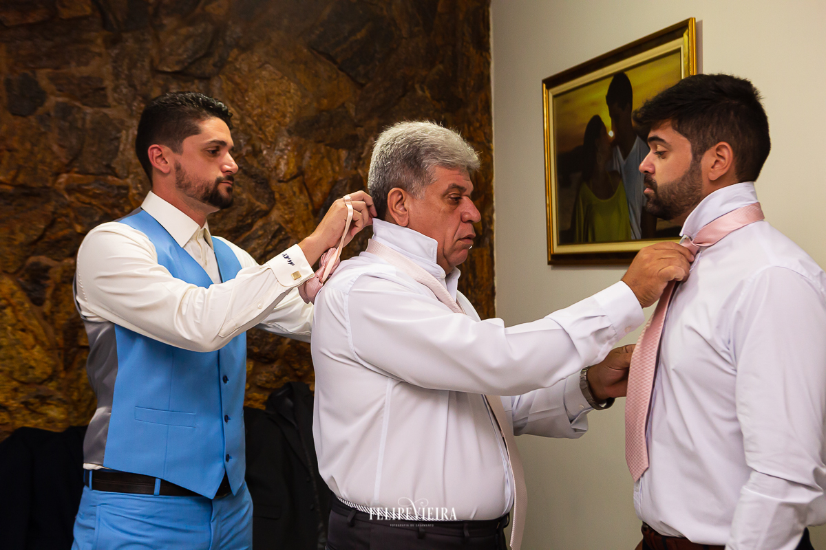 noivo ajeitando a gravata do pai que esta arrumando a gravata do irmão do noivo