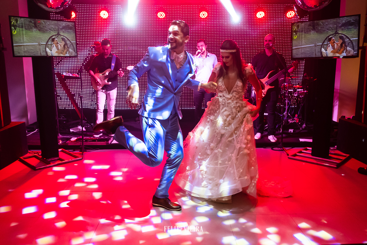 noivos dançando para abrir a pista de dança com iluminação vermelha