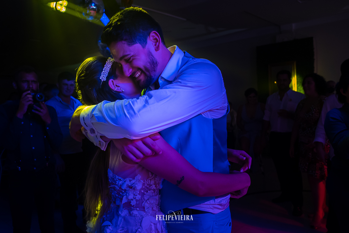 noivo abraçando a noiva e sorrindo durante dança