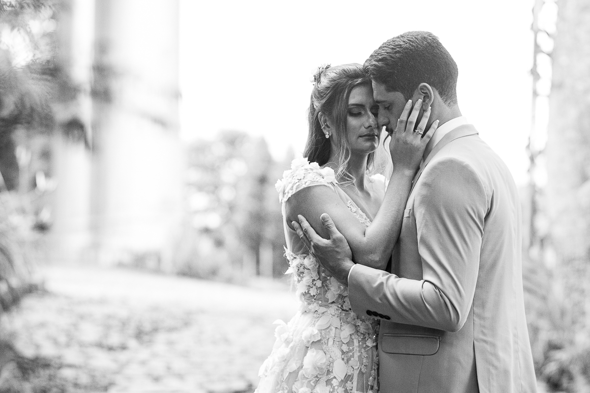 foto em preto e branco com a noiva acariciando o rosto do noivo