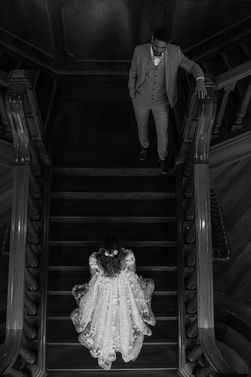 noivo olhando para nova numa escadaria de madeira 