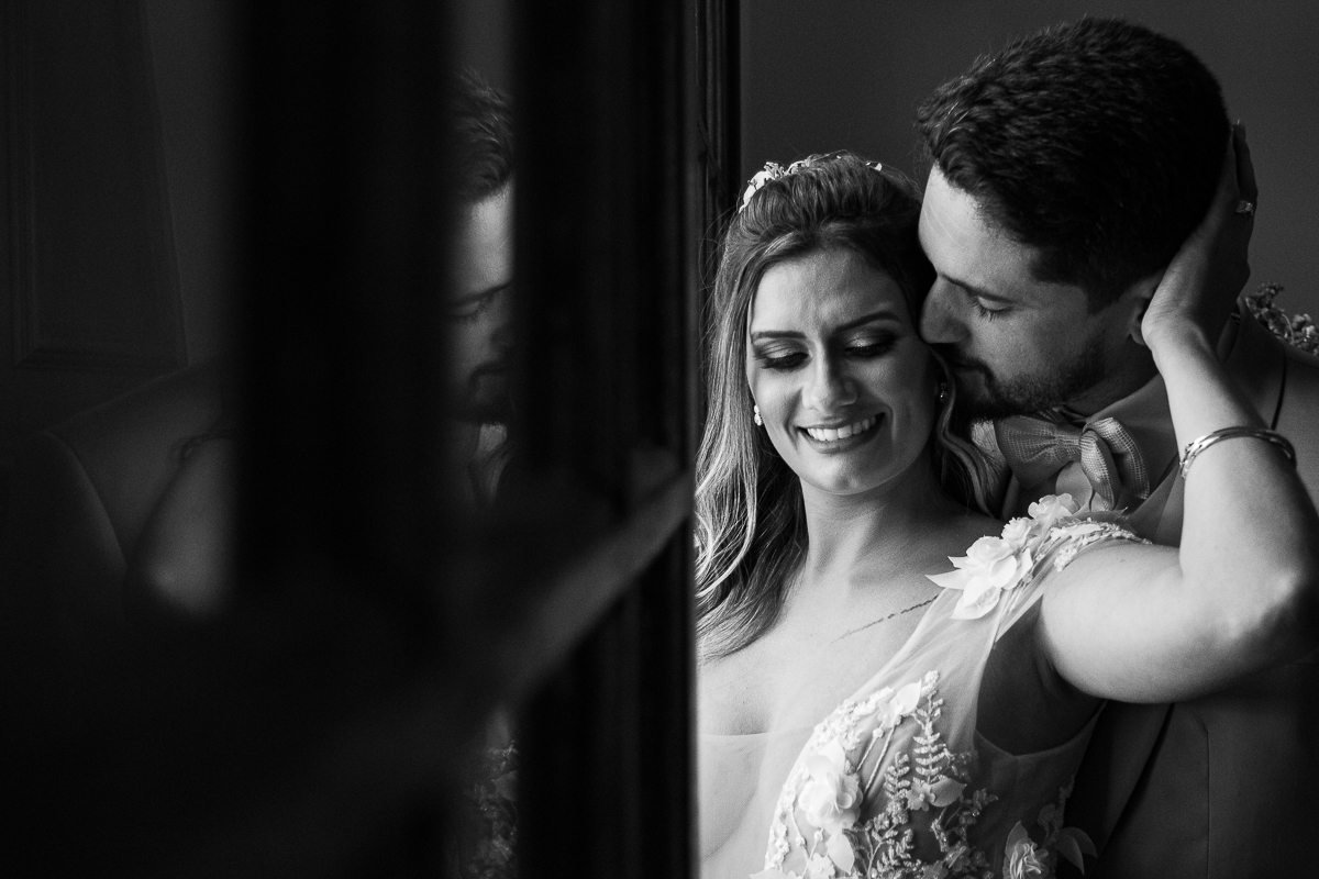 noiva sorrindo acariciando a nuca noivo que está beijando a noiva