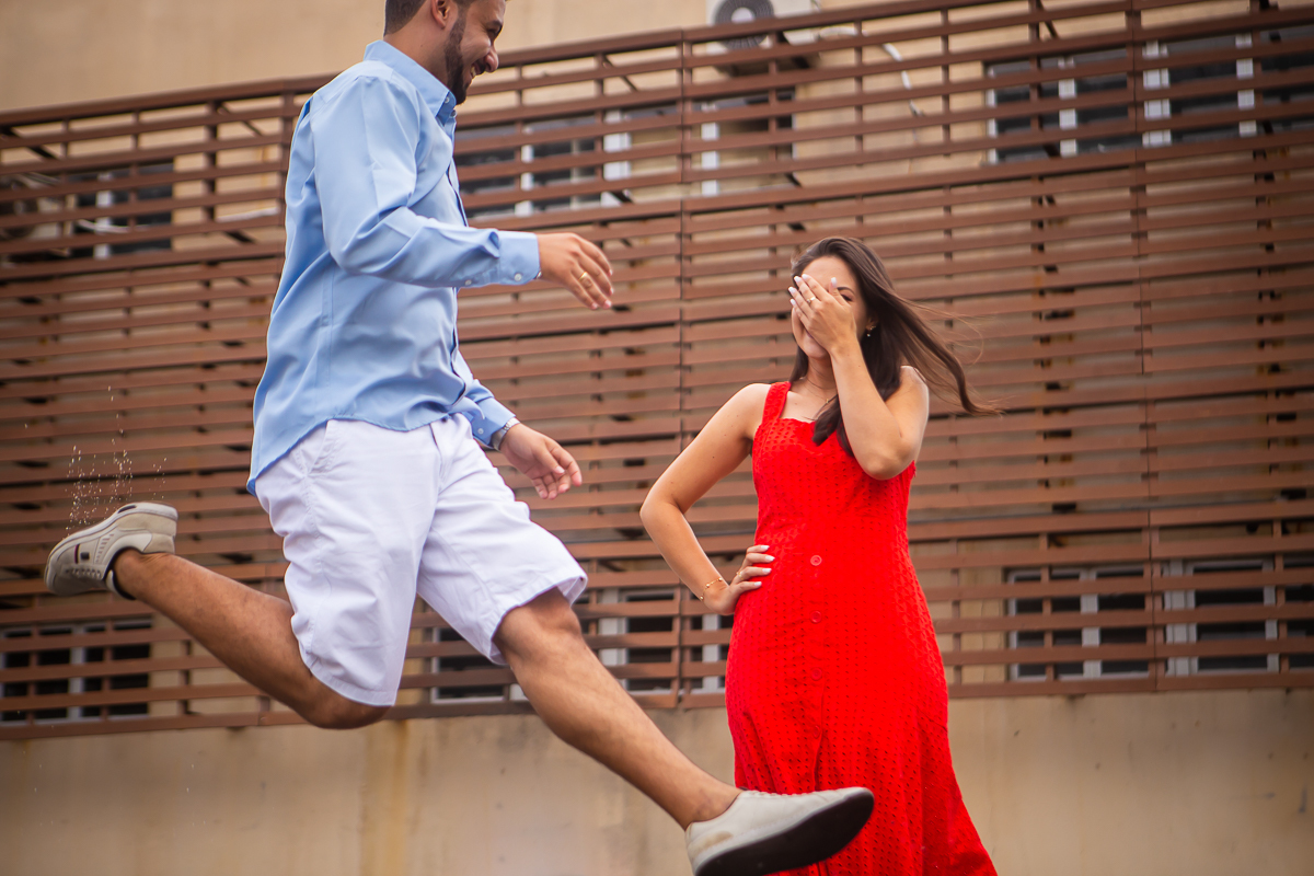 noivo pulando no meio da rua com a noiva com vestido vermelho 