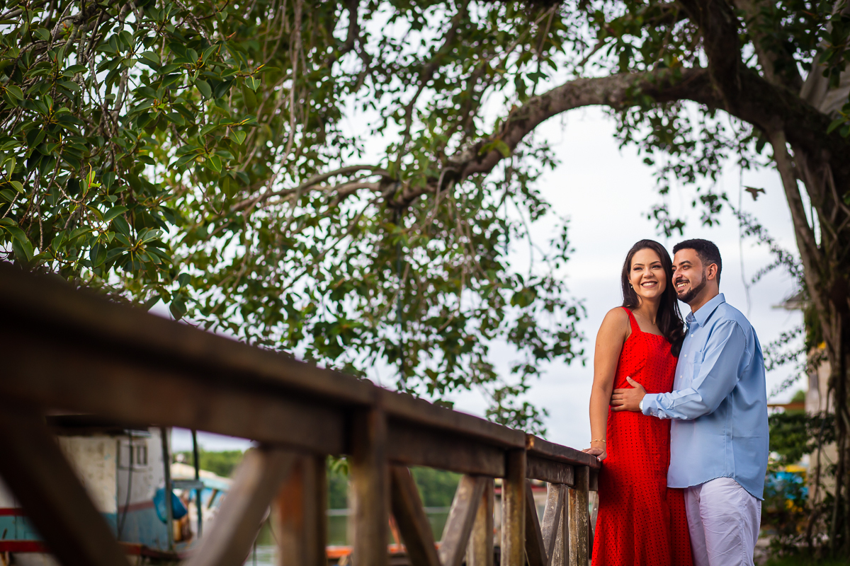 noivos no porto de Anchieta encostados na cerca de madeira