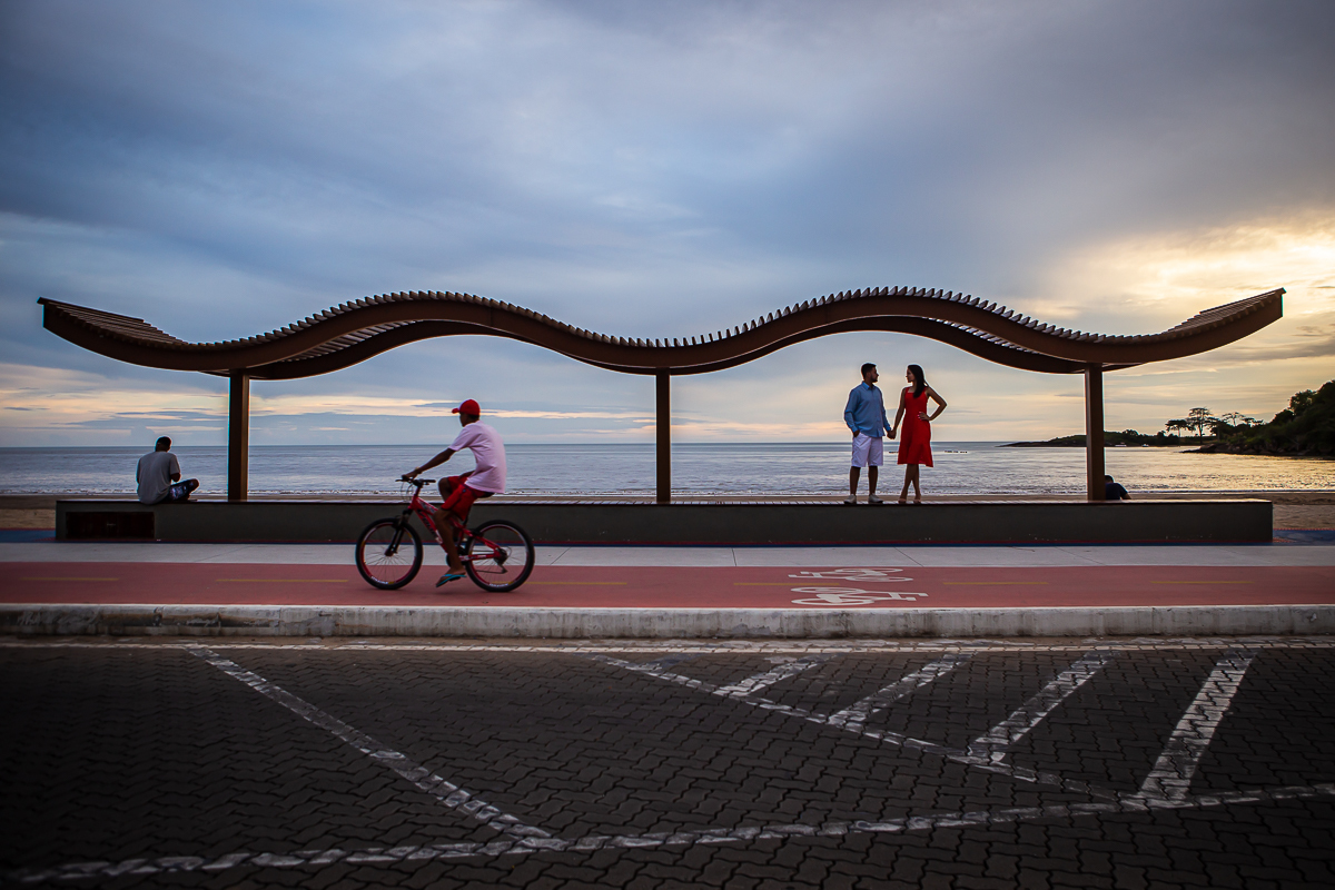 noivos no ponto de ônibus personalizado na praia de Anchieta com uma pessoa andando de bicicleta
