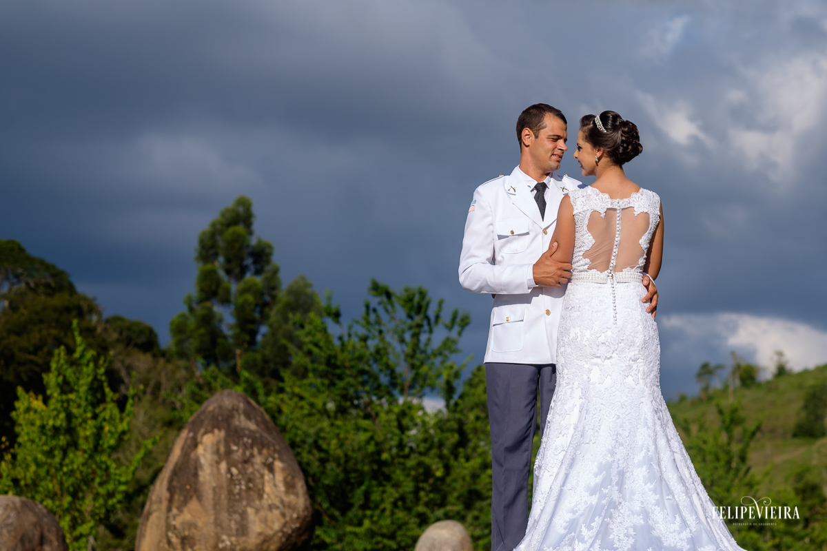 fotografia de Felipe Vieira fotografia de casamento do casal de Alegre-ES Franciele e Juliano noiva mostrando detalhe das costas do vestidoe noivo com farda militar