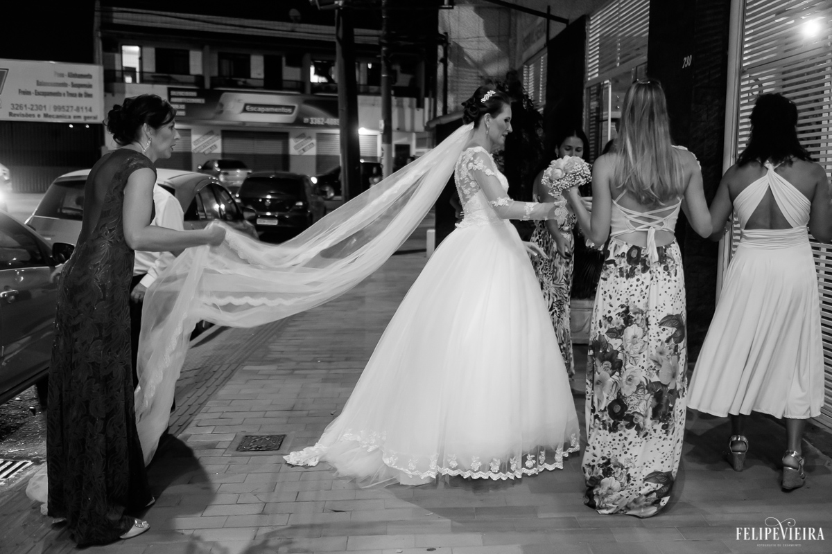 noiva saindo do carro em preto e branco em guarapari na frente do cerimonial se preparando para entrar foto de felipe vieira fotografo de casamento fvfotografo