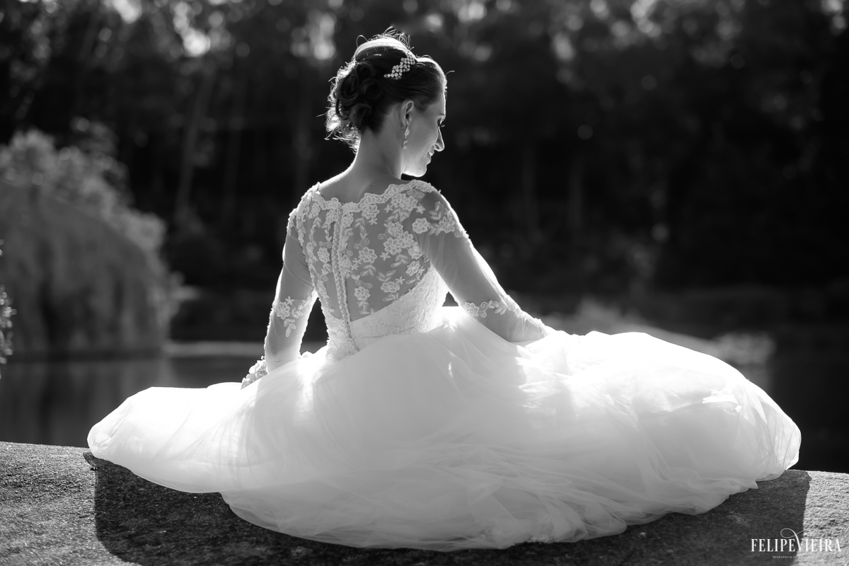 noiva sentada de costas de frente para o sol vestido branco na região serrana fotografo felipe vieira