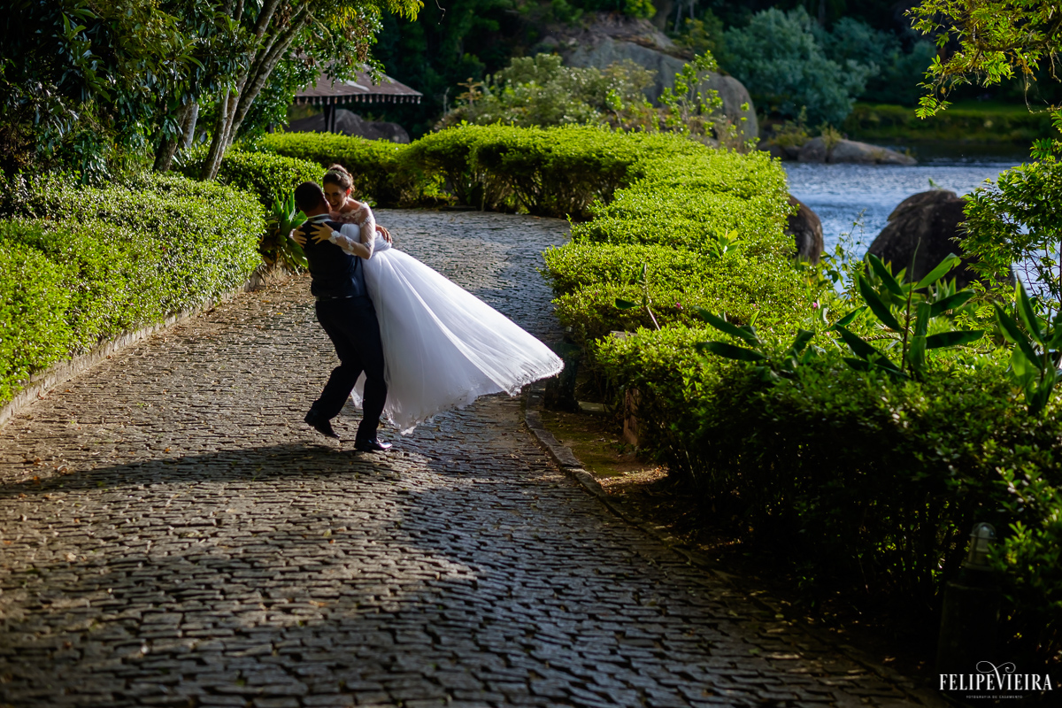 noivo pegando a noiva no colo rodando na estrada de paralelepídedos com verde na pousada pedra azul fvfotografo fotografia de felipe vieira