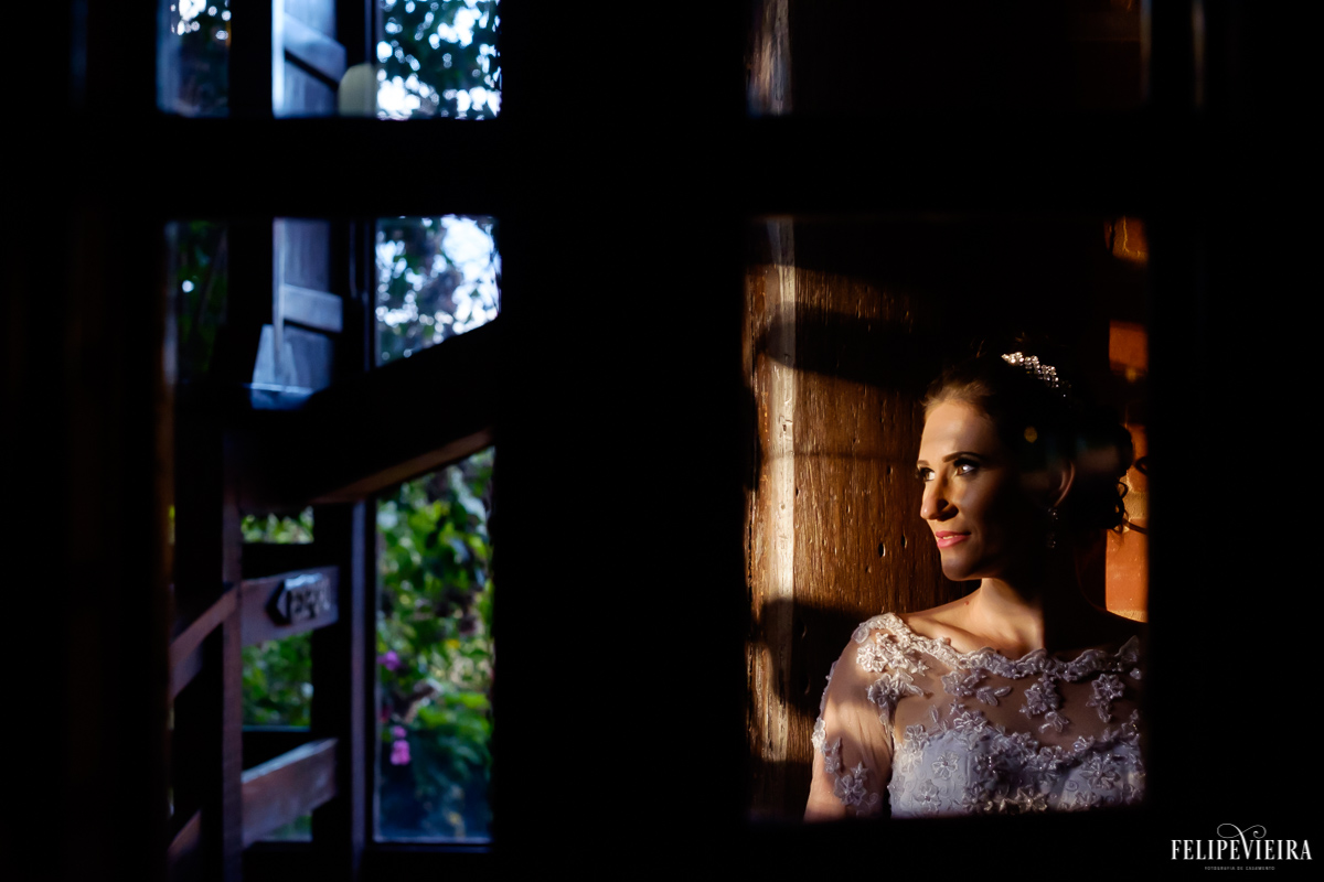noiva olhando para a paisagem da pousada pedra azul foto de felipe vieira fotografo de casamento em guarapari com luz e sombra