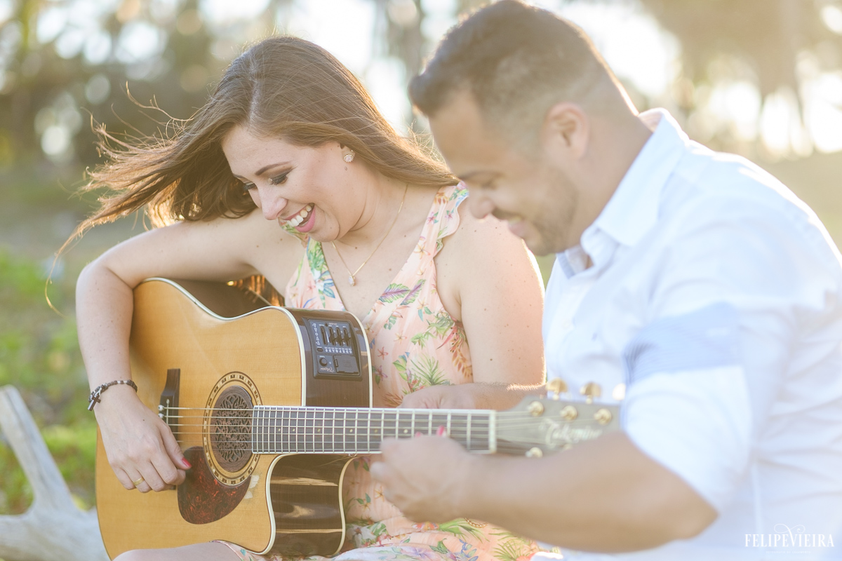 A Nana tentando aprender a tocar violão durante o ensaio pré wedding feito pelo fotógrafo Felipe Vieira em Guarapari