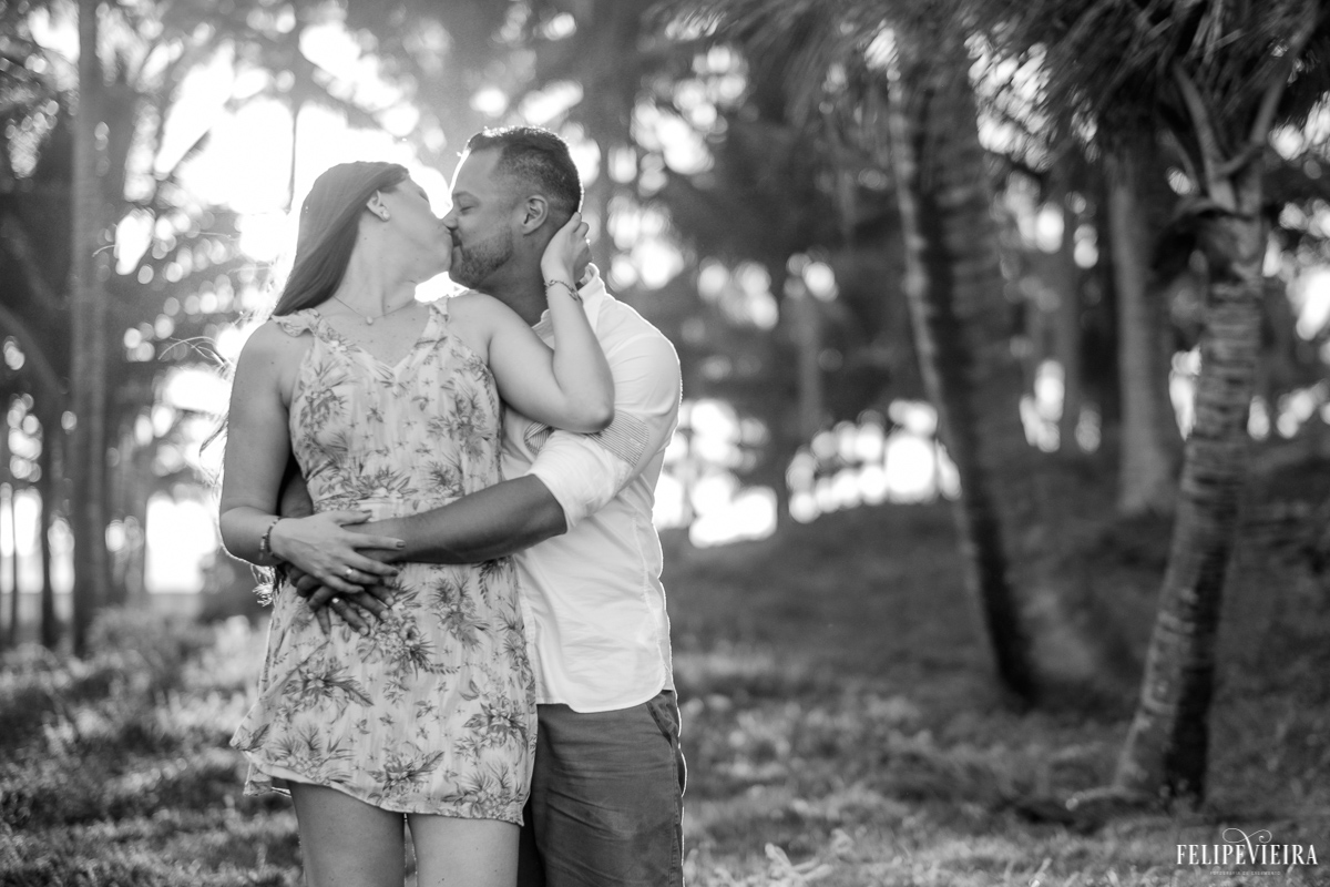 Ensaio pré wedding do Edy e da Nana foto em preto e branco no meio de uns coqueiros com o por do sol no fundo